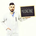 Doctor with beard holds little blackboard with word medicine