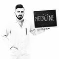Doctor with beard holds little blackboard with word medicine