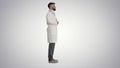 Doctor with a beard standing on gradient background.