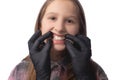 A doctor in black medical gloves examines the oral cavity of a little cute girl. Crooked teeth. Studio photo on a white background