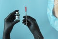A doctor in black medical gloves holds a syringe with covid19 vaccine. Vaccination concept, routine vaccination. World pandemic
