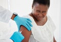Doctor, black woman and vaccine injection with pain on arm for safety, immunity and prevention. Covid, healthcare and