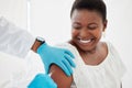 Doctor, black woman and vaccine injection with smile for safety, immunity and prevention. Covid, healthcare and medical