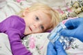 A doctor in blue gloves gives a sick child a pill with a medicine Royalty Free Stock Photo