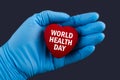 Doctor in blue gloves holds a heart with text World health day, concept Royalty Free Stock Photo