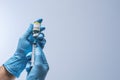 Doctor in blue latex gloves fill in syringe with vaccine from glass vial. Vaccination, immunization, treatment to Covid 19 Corona Royalty Free Stock Photo