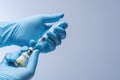 Doctor in blue latex gloves fill in syringe with vaccine from glass vial. Royalty Free Stock Photo