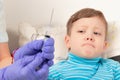 doctor in blue medical gloves injects a sick child with a syringe