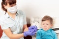 doctor in blue medical gloves injects a sick child with a syringe