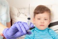 Doctor in blue medical gloves injects a sick child with a syringe