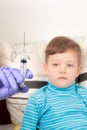 doctor in blue medical gloves injects a sick child with a syringe