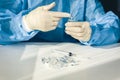 Doctor in a blue surgical gown and mask holds in his hand a medical syringe and bottle with insulin for diabetes. Many drugs for