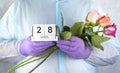 Doctor with a bouquet of flowers in his hands. medical worker in surgical gown and medical gloves