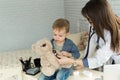 Doctor and boy patient examining teddy bear in Hospital. Royalty Free Stock Photo