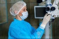 Doctor in breathing mask cheks surgical microscop in operation r Royalty Free Stock Photo