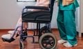Doctor carrying elderly patient in a wheelchair Royalty Free Stock Photo