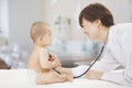 Doctor checking baby's heart beat with a stethoscope in the doctors office Royalty Free Stock Photo