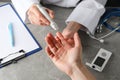 Doctor checking blood sugar level in patient diabetes on table