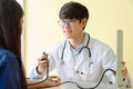 Doctor checking female patient blood pressure in medical office Royalty Free Stock Photo