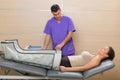 Doctor checking legs pressotherapy machine on woman