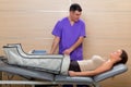 Doctor checking legs pressotherapy machine on woman