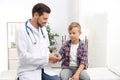 Doctor checking little boy`s pulse with medical device Royalty Free Stock Photo