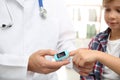 Doctor checking little boy`s pulse with medical device, closeup Royalty Free Stock Photo