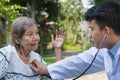 Doctor checking lung of elderly woman during homecare medical