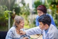 Doctor checking lung of elderly woman during homecare medical