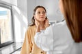 doctor checking lymph nodes of woman at hospital