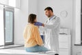 doctor checking lymph nodes of woman at hospital