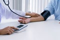 Doctor checking old woman patient arterial blood pressure. Health care Royalty Free Stock Photo