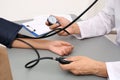 Doctor checking patient`s blood pressure at table Royalty Free Stock Photo