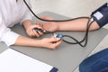 Doctor checking patient`s blood pressure at table in office Royalty Free Stock Photo