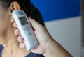 Doctor checking patient`s temperature in the ear with Tympanic Thermometer, inside the hospital or clinic. Royalty Free Stock Photo