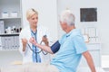 Doctor checking senior mans blood pressure Royalty Free Stock Photo