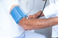 Doctor checking senior mans blood pressure Royalty Free Stock Photo