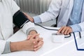 Doctor checking a senior patient blood pressure in office room Royalty Free Stock Photo