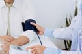 Doctor checking a senior patient blood pressure in office room Royalty Free Stock Photo
