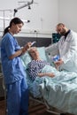 Doctor checking senior patient in hospital intensive care Royalty Free Stock Photo