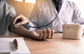 Doctor checking a senior patient`s blood pressure in office room Royalty Free Stock Photo