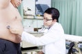 Doctor checking the stomach of overweight patient