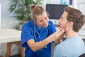 doctor checking throat on young male patient Royalty Free Stock Photo