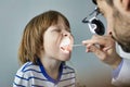 Doctor checking tonsils of patient at hospital