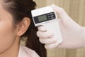 Doctor checking woman's ear with infra-red digital thermo Royalty Free Stock Photo