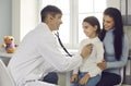 Doctor checking young patient& x27;s lungs or heartbeat during medical checkup at the hospital