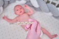 Doctor checks the temperature of the newborn baby with a thermometer. A nurse in uniform measures the child fever with a Royalty Free Stock Photo