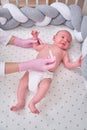 Doctor checks the temperature of the newborn baby with a thermometer. A nurse in uniform measures the child fever with a Royalty Free Stock Photo