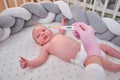 Doctor checks the temperature of the newborn baby with a thermometer. A nurse in uniform measures the child fever with a Royalty Free Stock Photo