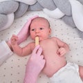 Doctor checks the throat of a newborn child with a plowshare. A nurse in uniform with a wooden stick in her hand examines the Royalty Free Stock Photo